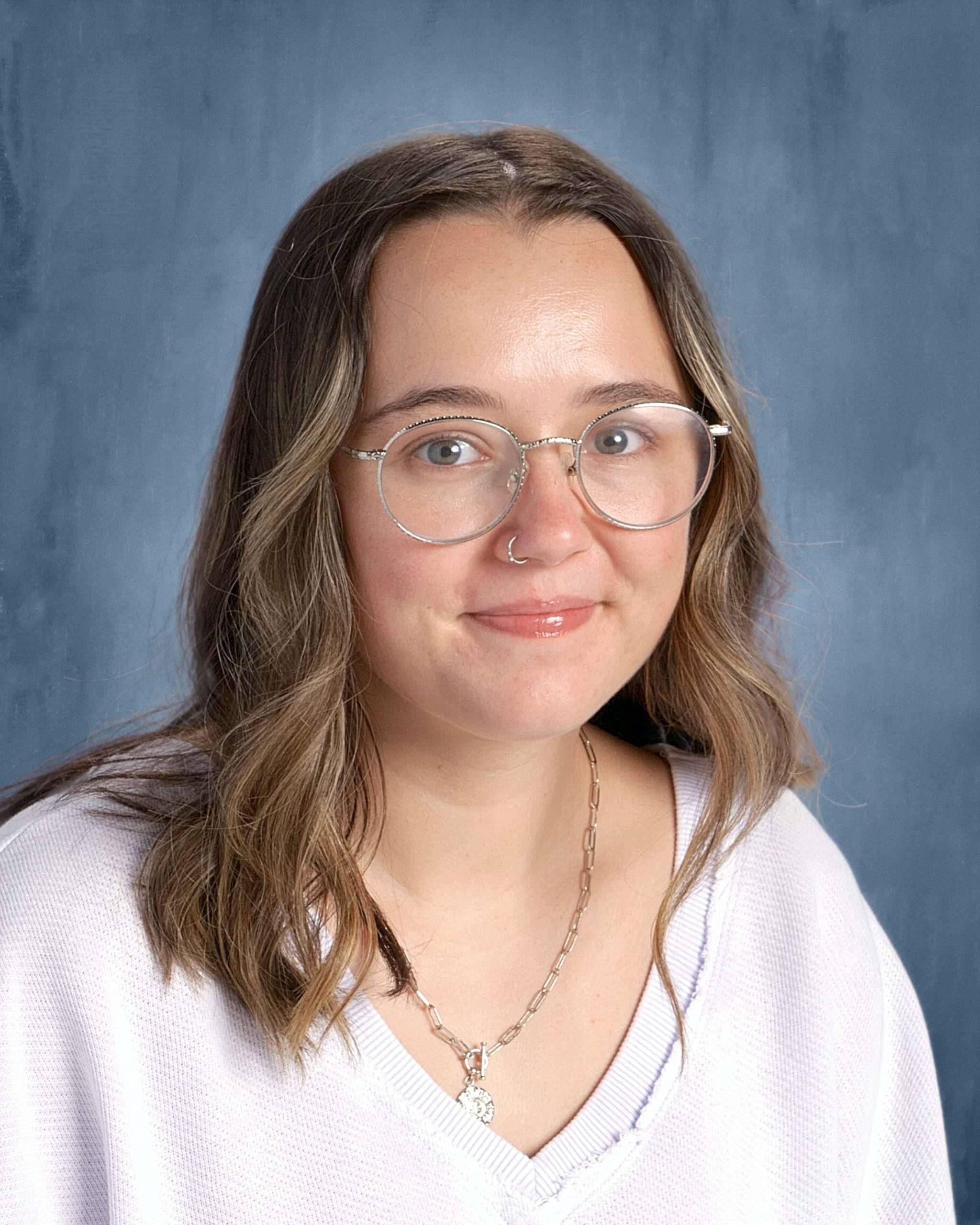 Photo of a woman in glasses wearing a white shirt